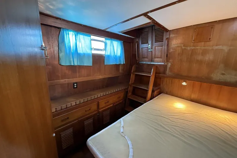 Slide: The Image of 1981 Marine Trader Double Cabin interior with wooden furnishings and blue curtains. - 33