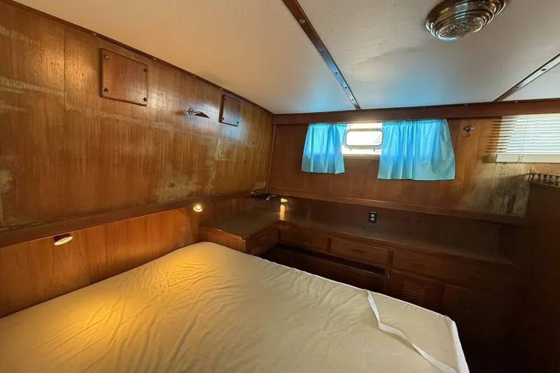 Slide: The Image of 1981 Marine Trader Double Cabin interior with wood paneling and blue curtains. - 34