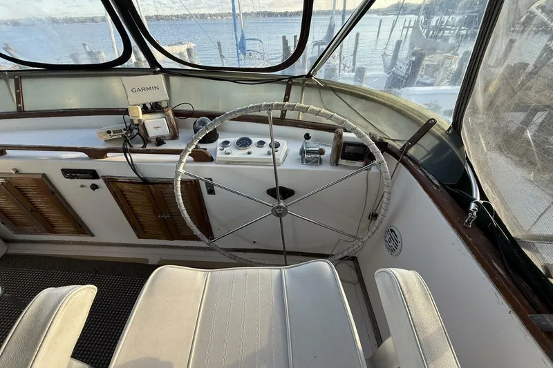 Slide: The Image of 1981 Marine Trader Double Cabin helm with steering wheel, navigation equipment, and waterfront view. - 40