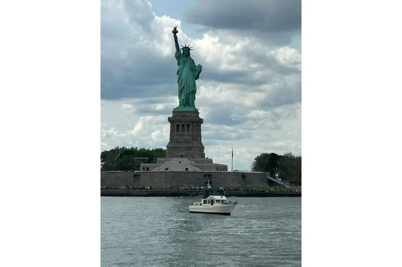 Slide: The Image of 1981 Marine Trader Double Cabin near Statue of Liberty under cloudy sky. - 55