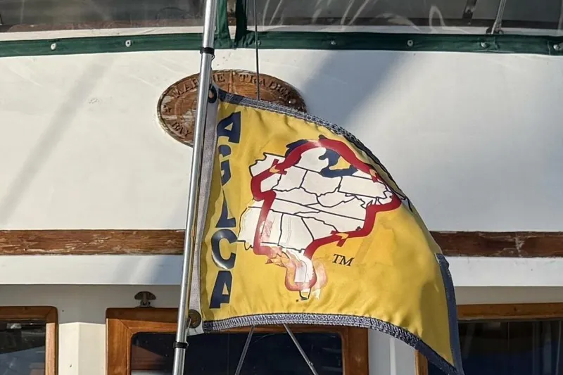 Slide: The Image of 1981 Marine Trader Double Cabin with a colorful flag featuring a map design. - 56