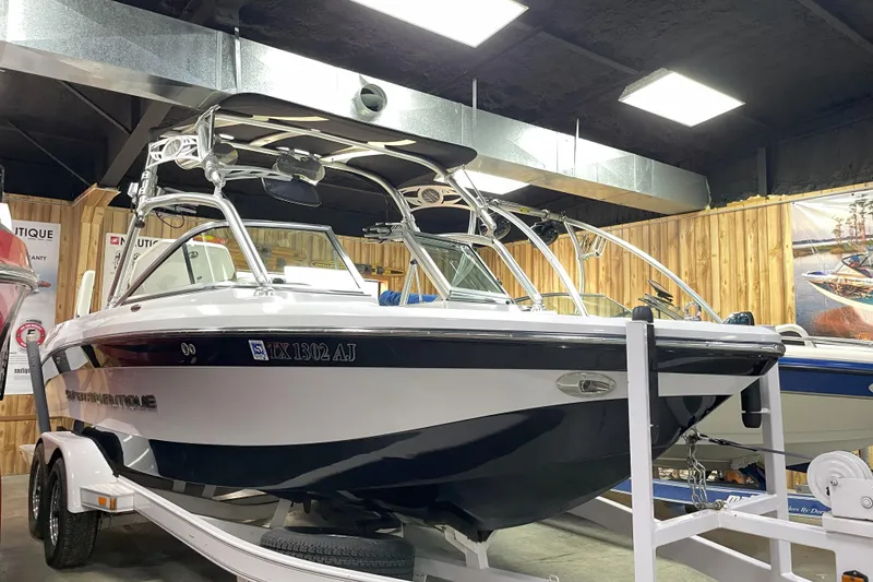 The Image of 2007 Nautique Super Air Nautique 220 boat on trailer in showroom. - 1