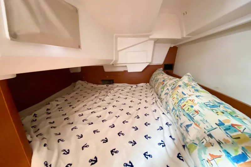Slide: The Image of Cozy cabin interior of 2016 Beneteau Oceanis 35 with nautical-themed bedding. - 18