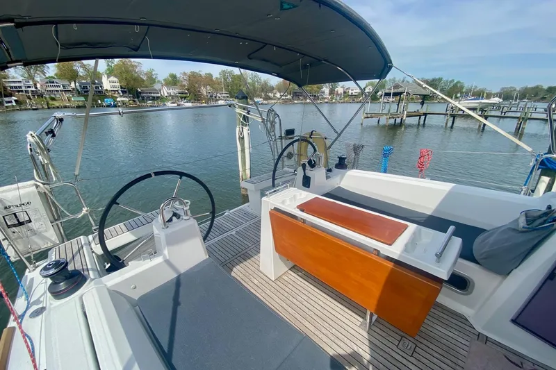 Slide: The Image of 2016 Beneteau Oceanis 35 sailboat cockpit with helm, seating, and waterfront view. - 41
