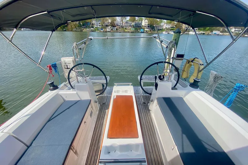 Slide: The Image of 2016 Beneteau Oceanis 35 sailboat cockpit with dual steering wheels and waterfront view. - 42