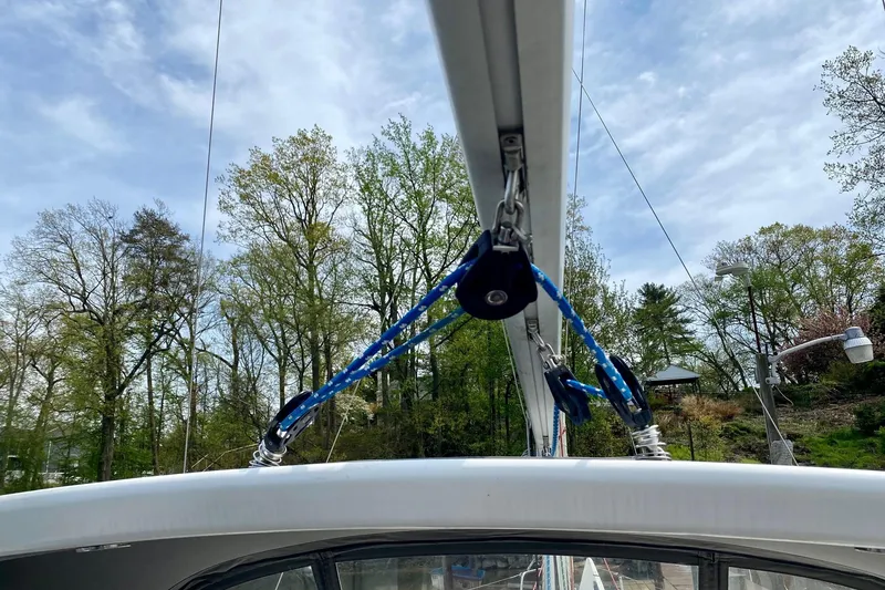 Slide: The Image of Sailboat rigging on a 2016 Beneteau Oceanis 35 against a backdrop of trees and sky. - 49