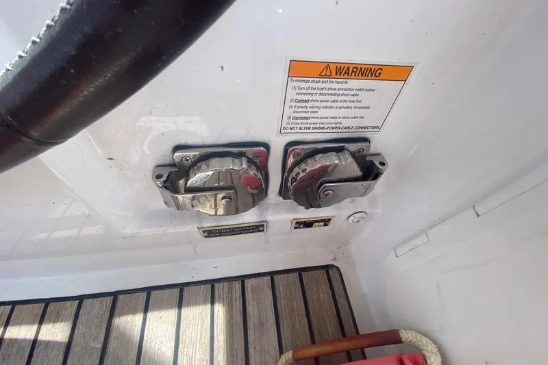 Slide: The Image of Beneteau Oceanis 35 (2016) boat controls with warning label and wooden deck. - 53