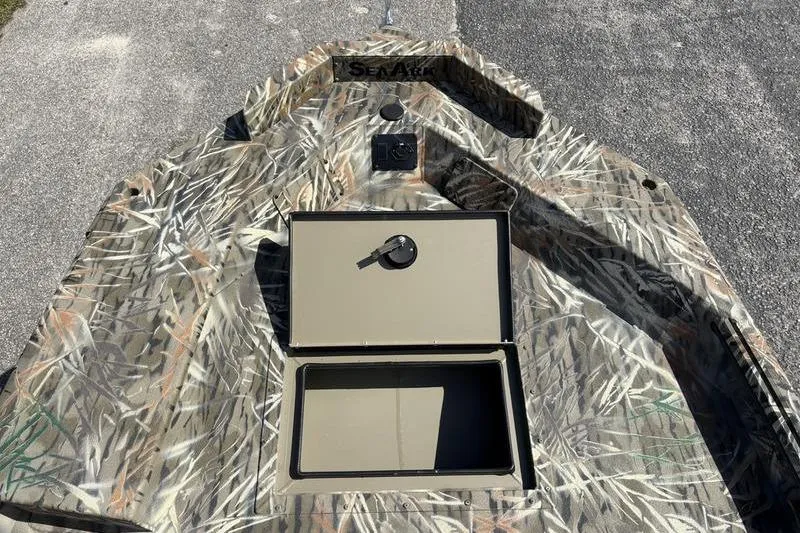 Slide: The Image of 2026 SeaArk 1752 Slayer boat with camo design and open storage compartment. - 13