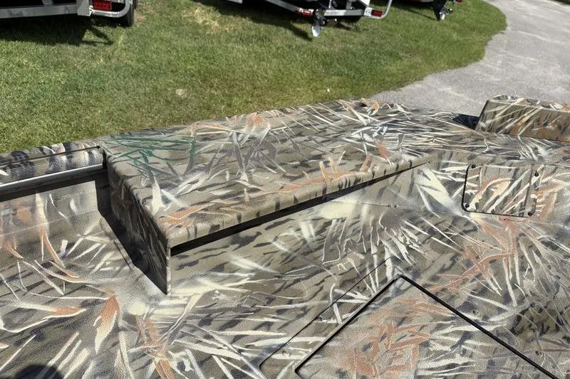 Slide: The Image of 2026 SeaArk 1752 Slayer boat with camouflage pattern on grass. - 14