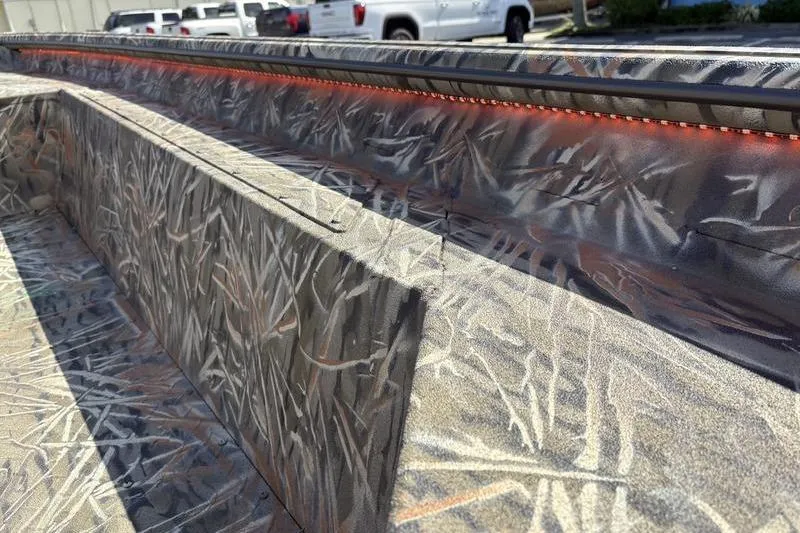 Slide: The Image of 2026 SeaArk 1752 Slayer boat interior with camo pattern and orange LED lighting. - 17