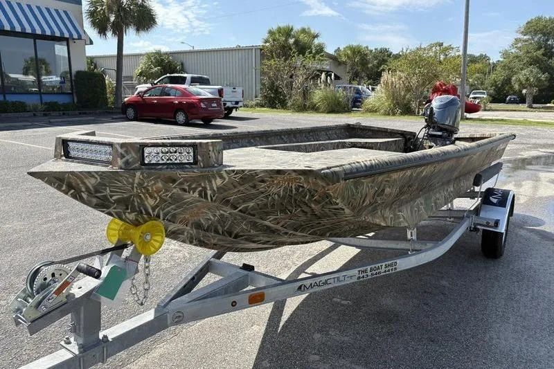 Slide: The Image of 2026 SeaArk 1752 Slayer boat with camouflage design on a trailer in a parking lot. - 7