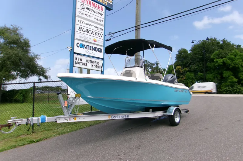 Slide: The Image of 2026 Key West 189 FS boat on trailer, displayed outdoors near dealership signs. - 23