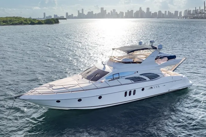 Slide: The Image of 2007 Azimut 62 Evolution yacht cruising on water with city skyline in background. - 12