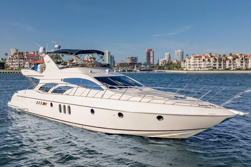 Slide: The Image of 2007 Azimut 62 Evolution yacht cruising near luxury waterfront buildings. - 18