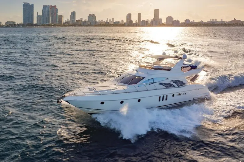 Slide: The Image of Luxurious 2007 Azimut 62 Evolution yacht cruising near a city skyline at sunset. - 3