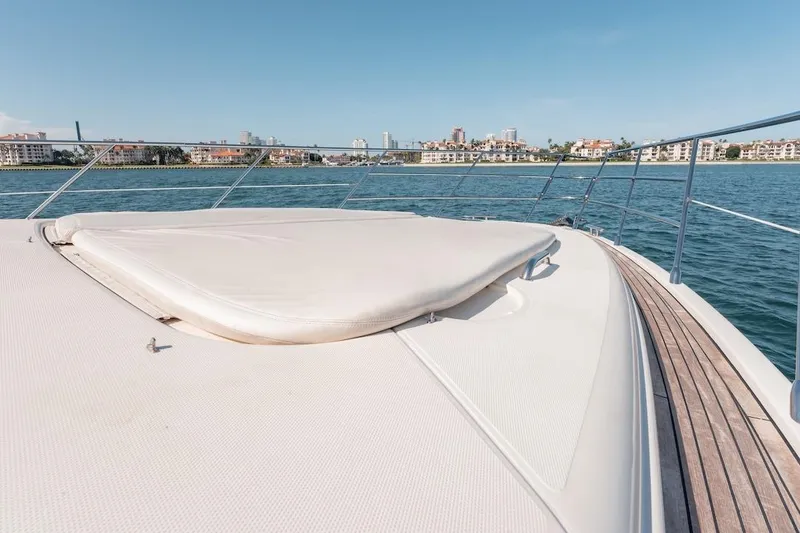 Slide: The Image of 2007 Azimut 62 Evolution yacht deck with sun pad, overlooking coastal cityscape. - 31