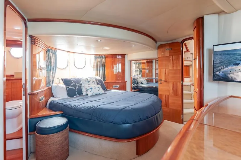 Slide: The Image of Luxurious 2007 Azimut 62 Evolution yacht bedroom with elegant wood finishes and cozy bedding. - 62