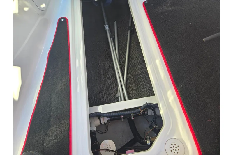 Slide: The Image of 2012 Sea-Doo Sport Boats 210 Wake interior storage compartment with visible piping and rods. - 14