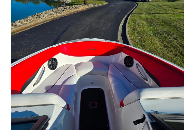 Slide: The Image of 2012 Sea-Doo Sport Boats 210 Wake interior with red and white seating, near water. - 17