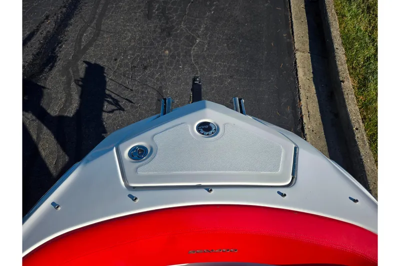 Slide: The Image of 2012 Sea-Doo Sport Boats 210 Wake, red and white deck, parked on pavement. - 18