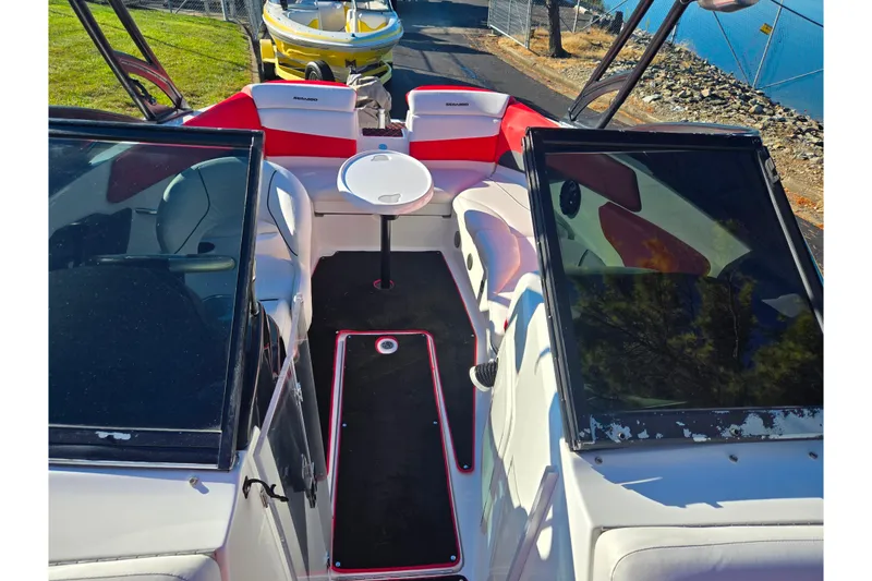 Slide: The Image of 2012 Sea-Doo Sport Boats 210 Wake interior with seating and table, docked near water. - 20