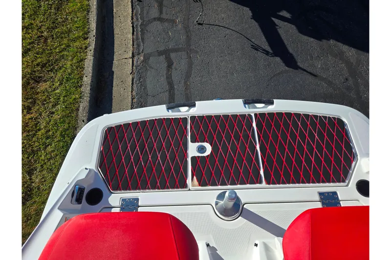 Slide: The Image of 2012 Sea-Doo 210 Wake boat with red seats and deck, parked on pavement. - 25