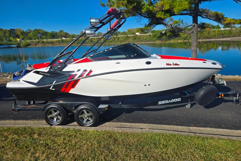 Slide: The Image of 2012 Sea-Doo Sport Boats 210 Wake on trailer by a scenic lake. - 9