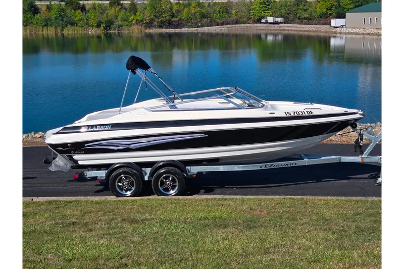 The Image of 2007 Larson LXi 228 boat on trailer by a lake, ready for transport. - 0