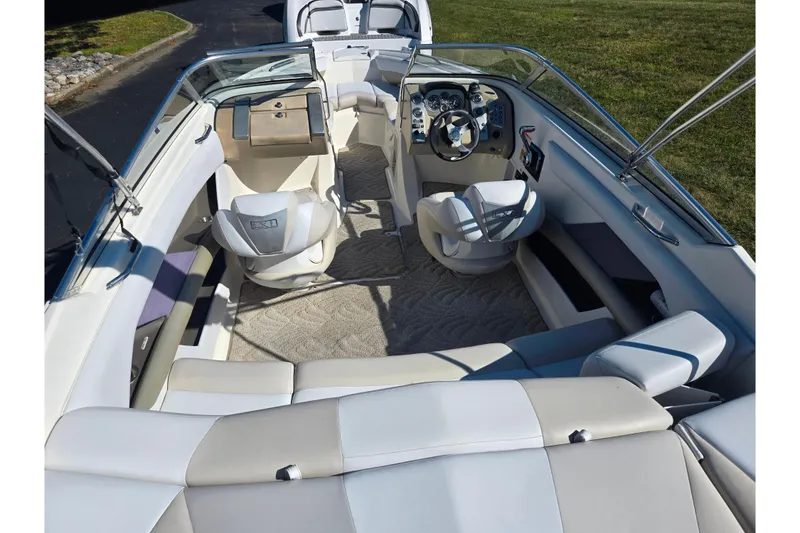 Slide: The Image of 2007 Larson LXi 228 boat interior with white seating and modern dashboard. - 10