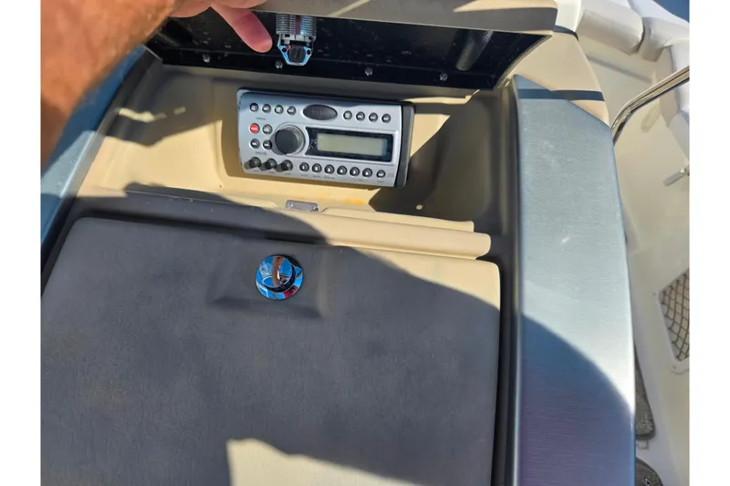 Slide: The Image of 2007 Larson LXi 228 boat dashboard with stereo system and storage compartment. - 12