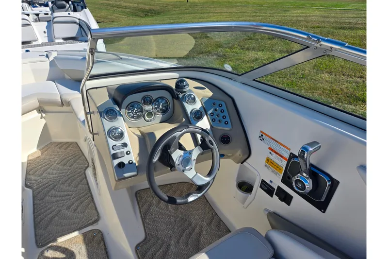 Slide: The Image of 2007 Larson LXi 228 boat dashboard with steering wheel and control panel. - 15