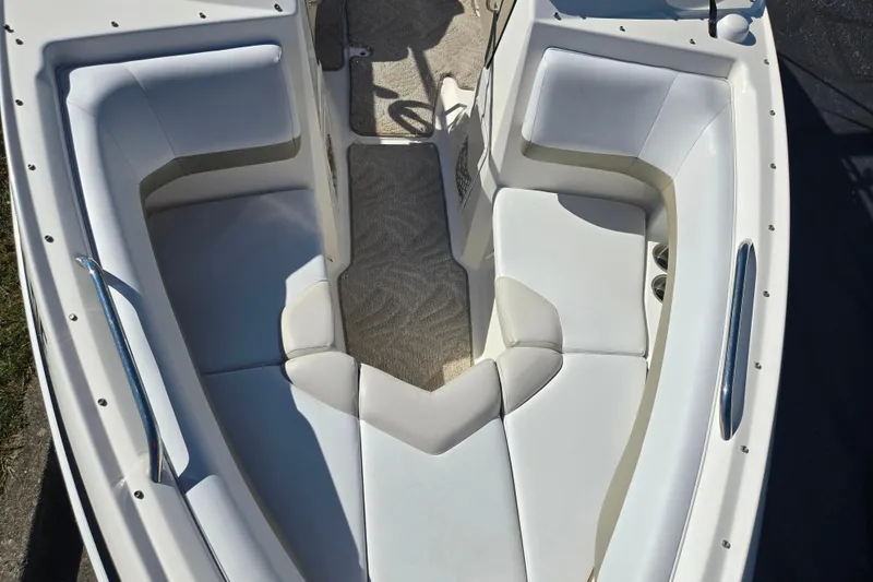 Slide: The Image of 2007 Larson LXi 228 boat interior with white cushioned seating and carpeted floor. - 18