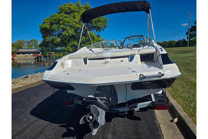 Slide: The Image of 2007 Larson LXi 228 boat on trailer, rear view, sunny day, near water and trees. - 2