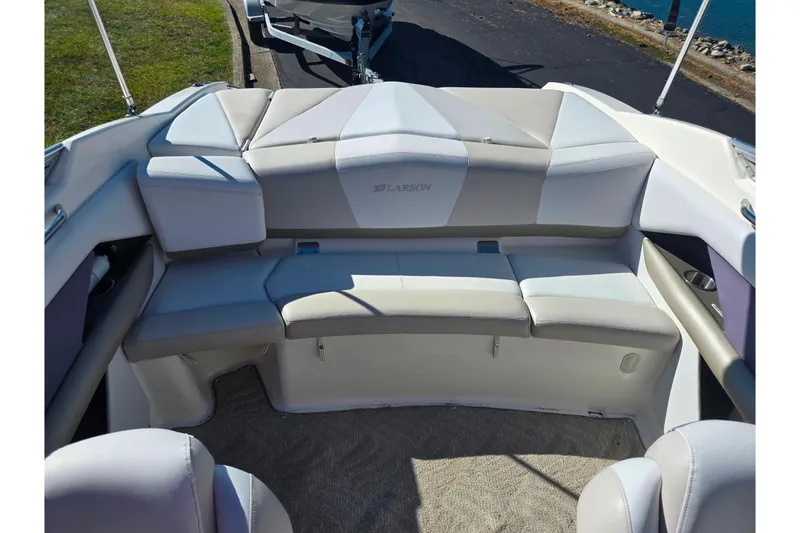 Slide: The Image of 2007 Larson LXi 228 boat interior with cushioned seating and carpeted floor. - 21