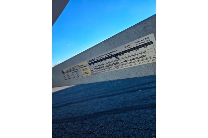 Slide: The Image of 2007 Larson LXi 228 boat trailer label with specifications under clear blue sky. - 26