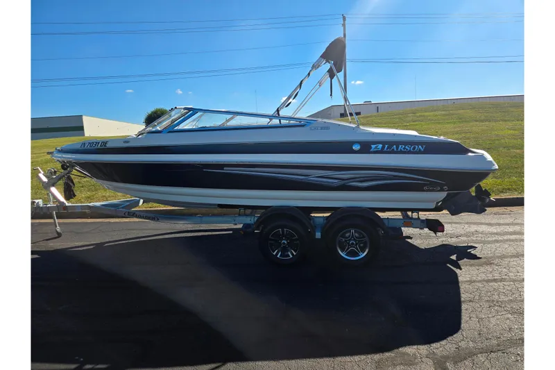 Slide: The Image of 2007 Larson LXi 228 boat on trailer, parked outdoors under clear blue sky. - 4