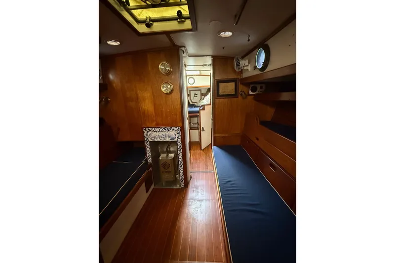 Slide: The Image of 1981 Kaiser 34' Gale Force offshore cutter cockpit with wooden seating and green covers. - 2