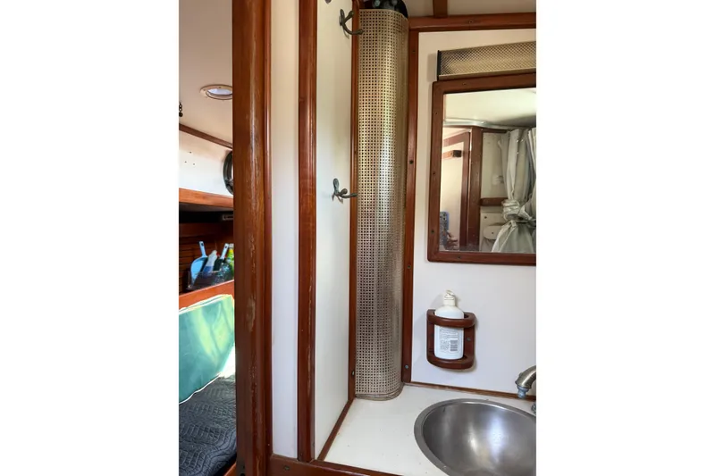 Slide: The Image of 1981 Kaiser 34' Gale Force offshore cutter bathroom with sink, mirror, and wooden cabinetry. - 22