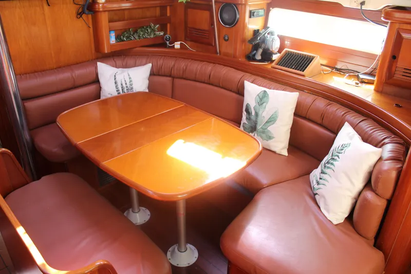 Slide: The Image of Interior of 2001 Beneteau 411 yacht with cozy dining area and decorative pillows. - 20