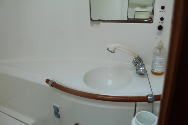 Slide: The Image of Bathroom sink area in a 2001 Beneteau 411 yacht, featuring faucet and mirror. - 32
