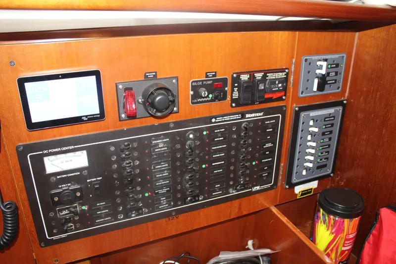 Slide: The Image of Control panel of a 2001 Beneteau 411 sailboat, featuring various switches and displays. - 38