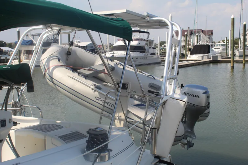Slide: The Image of Beneteau 411 sailboat with dinghy and Honda outboard motor at marina, 2001 model. - 6