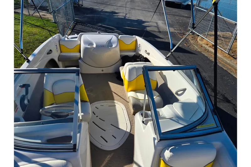 Slide: The Image of 2006 Tahoe Q4 Sport boat interior with yellow and white seating, docked near water. - 18