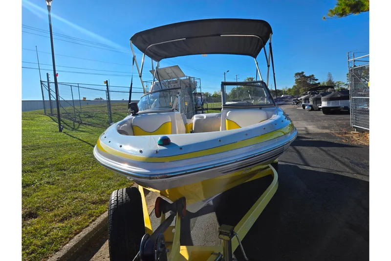 Slide: The Image of 2006 Tahoe Q4 Sport boat with canopy on trailer, parked outdoors. - 6