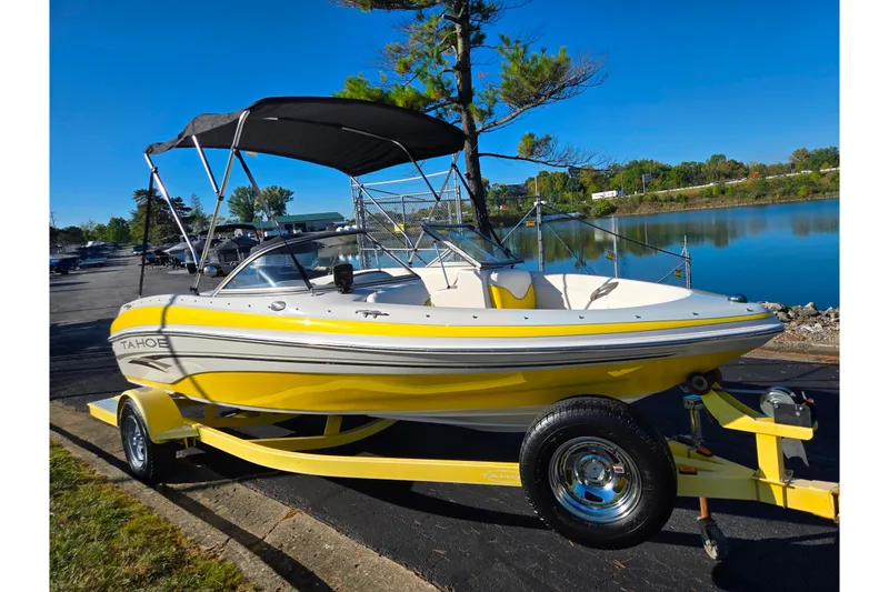 Slide: The Image of 2006 Tahoe Q4 Sport boat with yellow hull on trailer by a lake. - 8