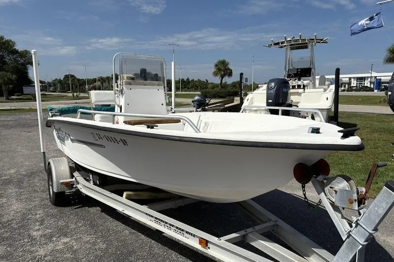 Slide: The Image of 2004 Carolina Skiff 175 boat on trailer, parked outdoors under a clear sky. - 3