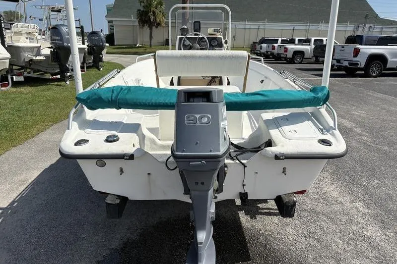 Slide: The Image of 2004 Carolina Skiff 175 boat with 90 HP outboard motor, parked outdoors. - 6