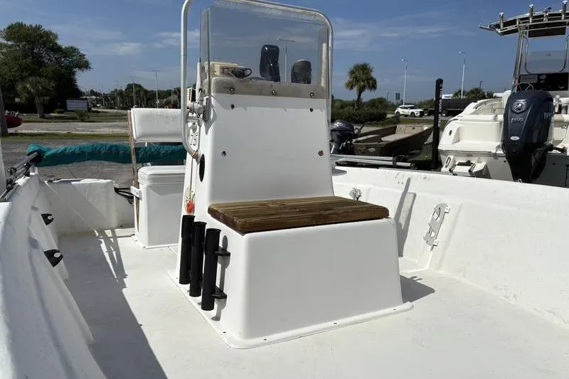 Slide: The Image of 2004 Carolina Skiff 175 boat interior with console and seating, parked outdoors. - 9
