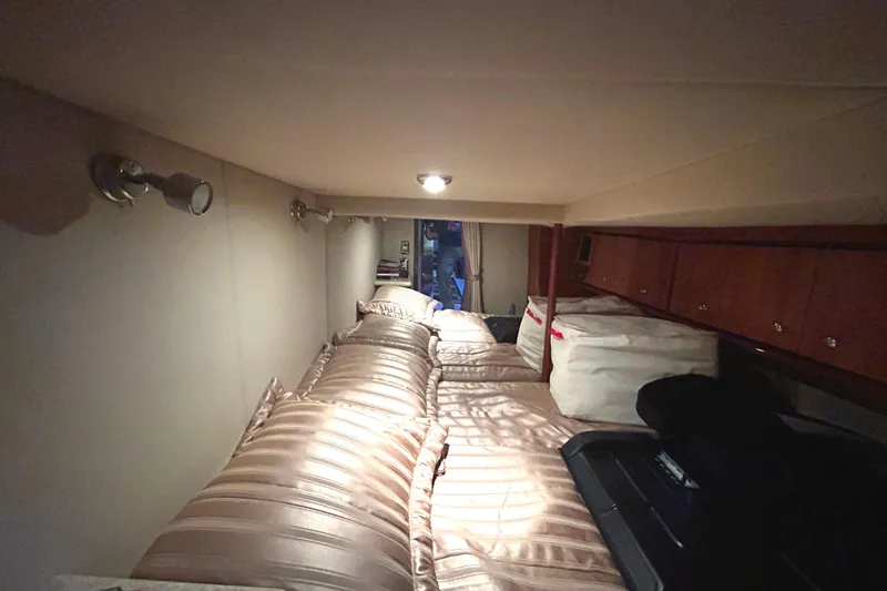 Slide: The Image of 2005 Fountain 48 Express Cruiser cabin interior with cozy bedding and ambient lighting. - 15