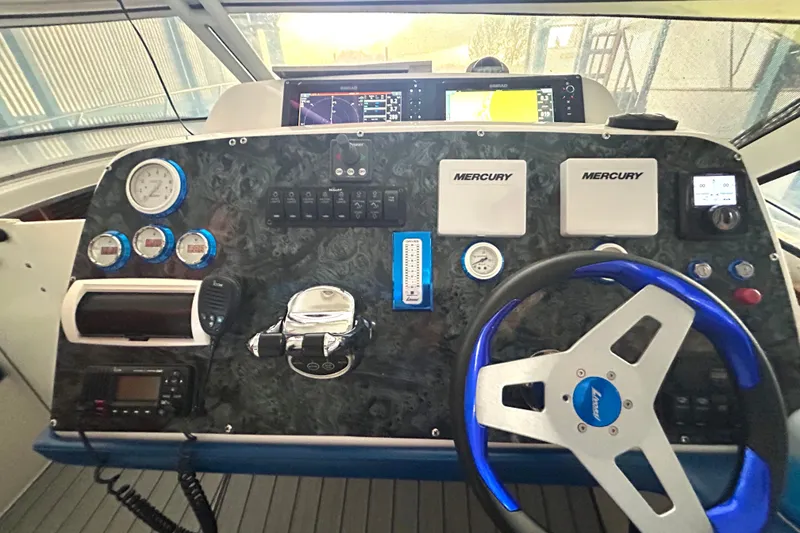 Slide: The Image of Control panel of a 2005 Fountain 48 Express Cruiser with Mercury gauges and steering wheel. - 18